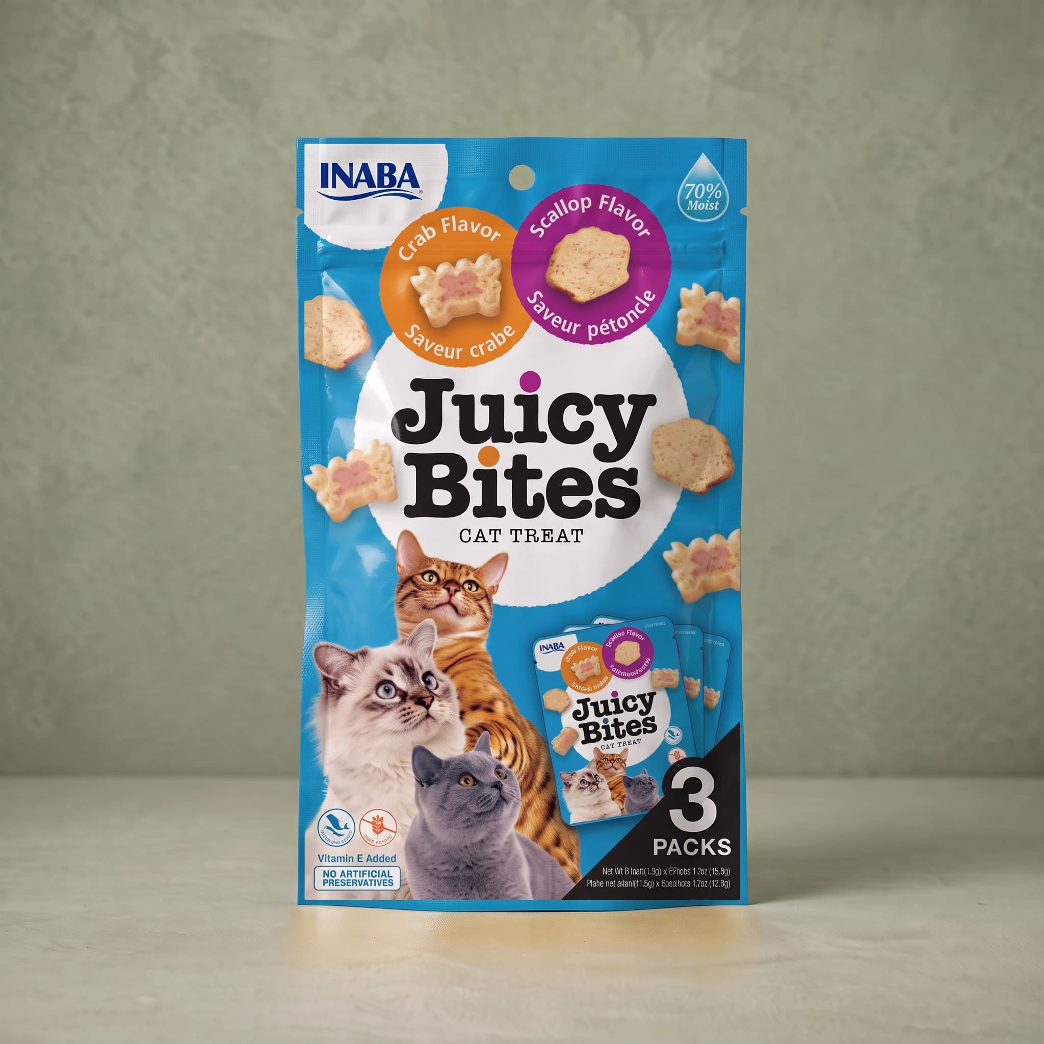 Bright blue INABA Juicy Bites cat treat pouch in the Crab and Scallop flavours, with an orange 'Crab Flavor' roundel showing a crab-shaped treat and a magenta 'Scallop Flavor' roundel showing a scallop-shaped treat, a '70% Moist' droplet flash, photographs of three cats, and a '3 PACKS' panel.
