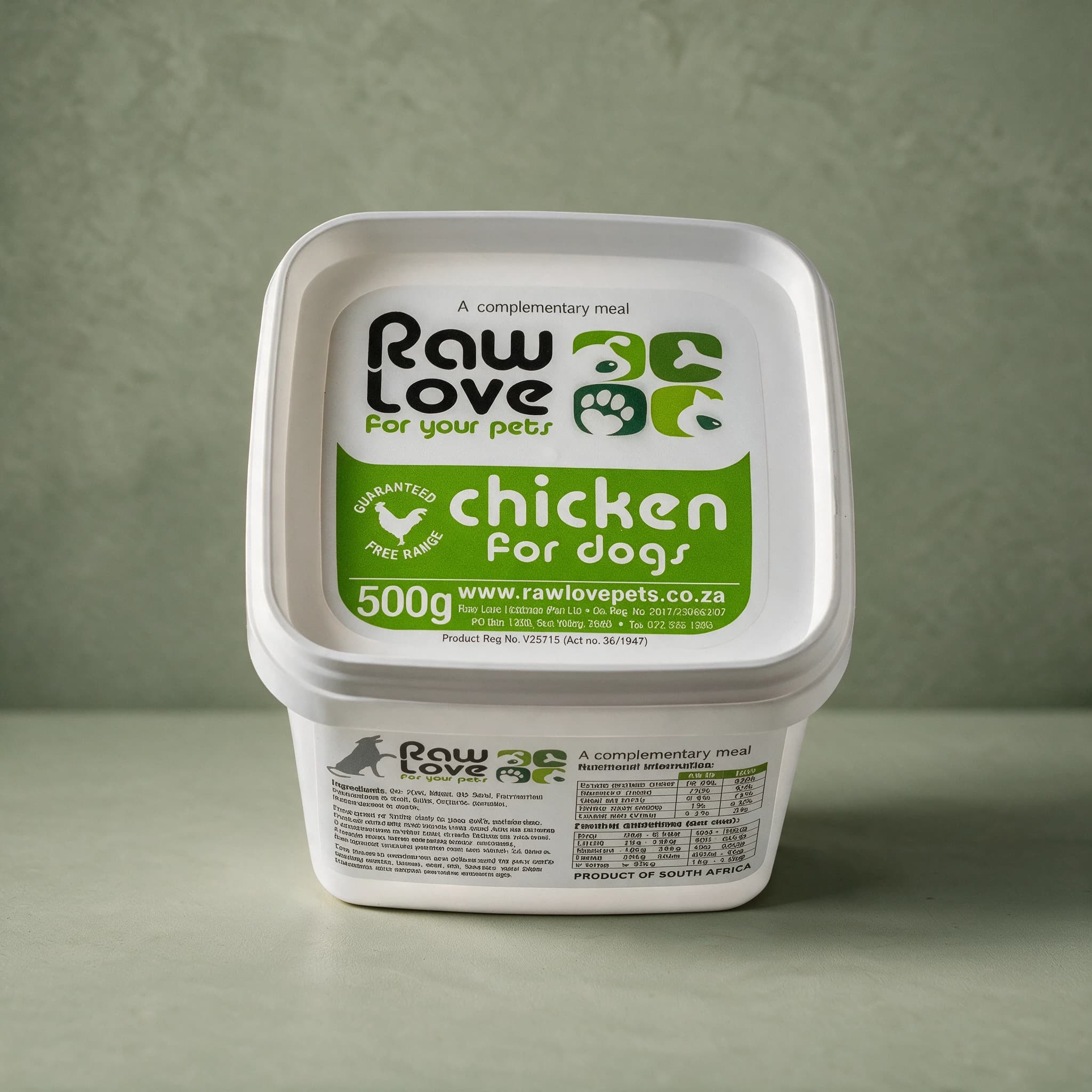White 500g tub of Raw Love Chicken for Dogs raw frozen food, green label panel with the Raw Love logo, a free-range chicken roundel and the words 'A complementary meal', photographed against a sage green background.