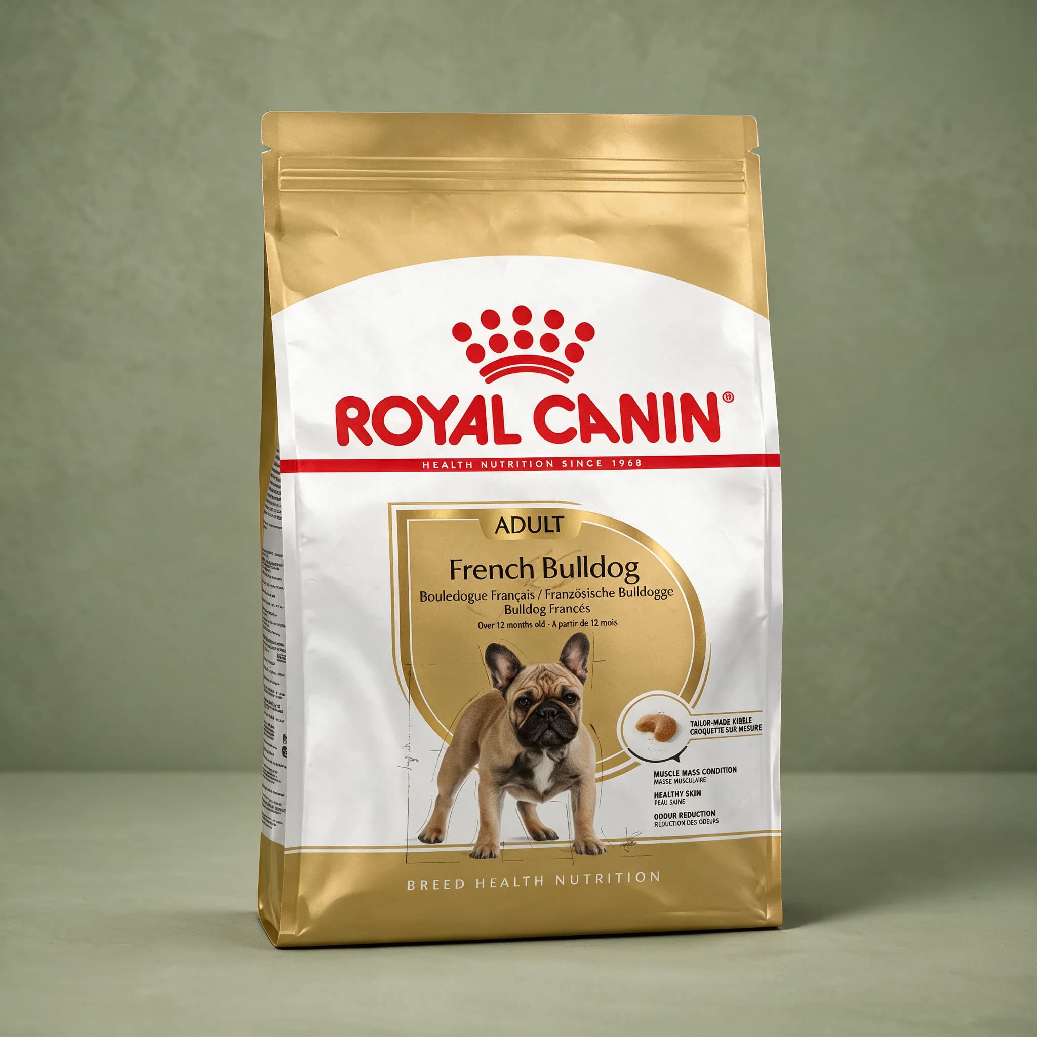 The gold and white Royal Canin Breed Health Nutrition bag labeled "French Bulldog Adult" with an illustration of a French Bulldog, photographed against a plain sage green studio background.