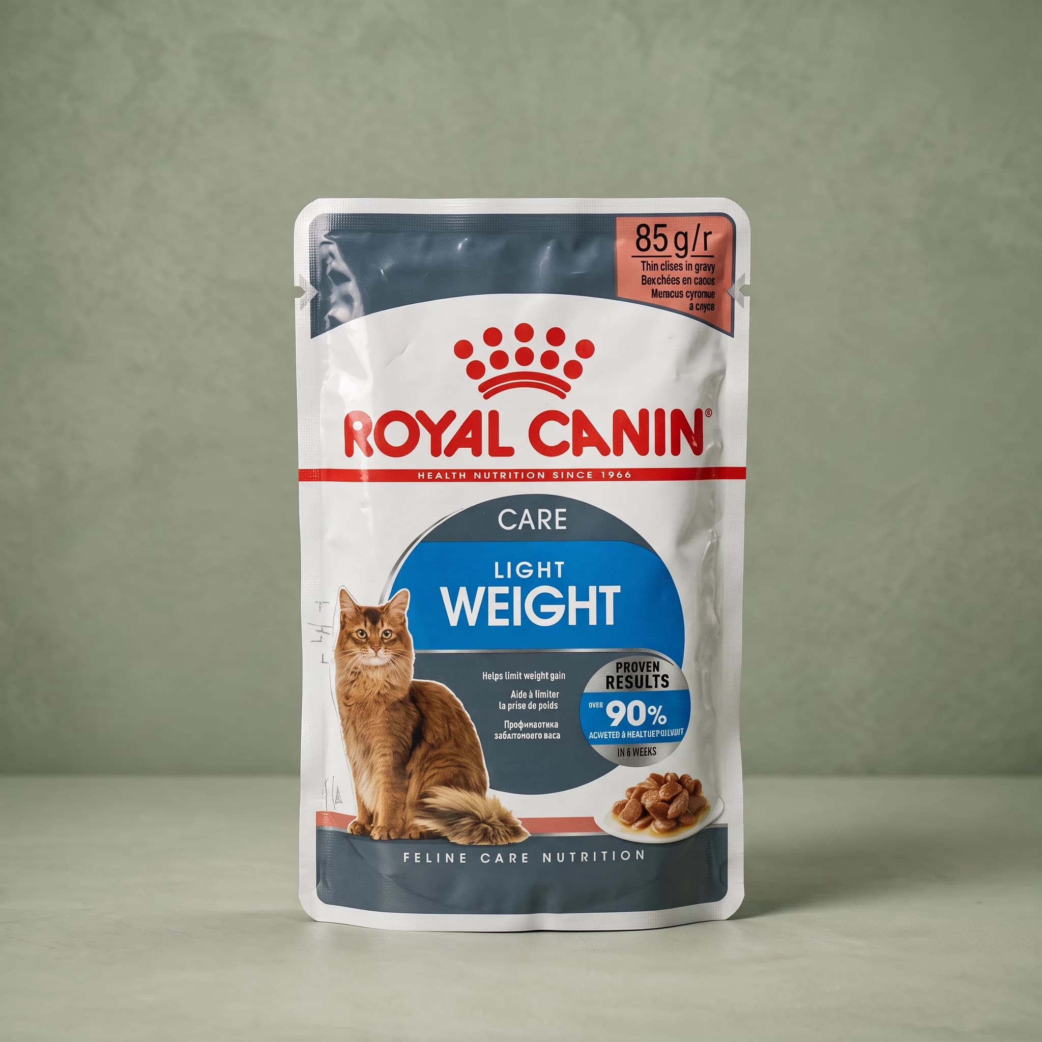 A Royal Canin Light Weight Care wet cat food pouch with the red crown logo and an adult cat illustration, standing upright against a plain sage green studio background.