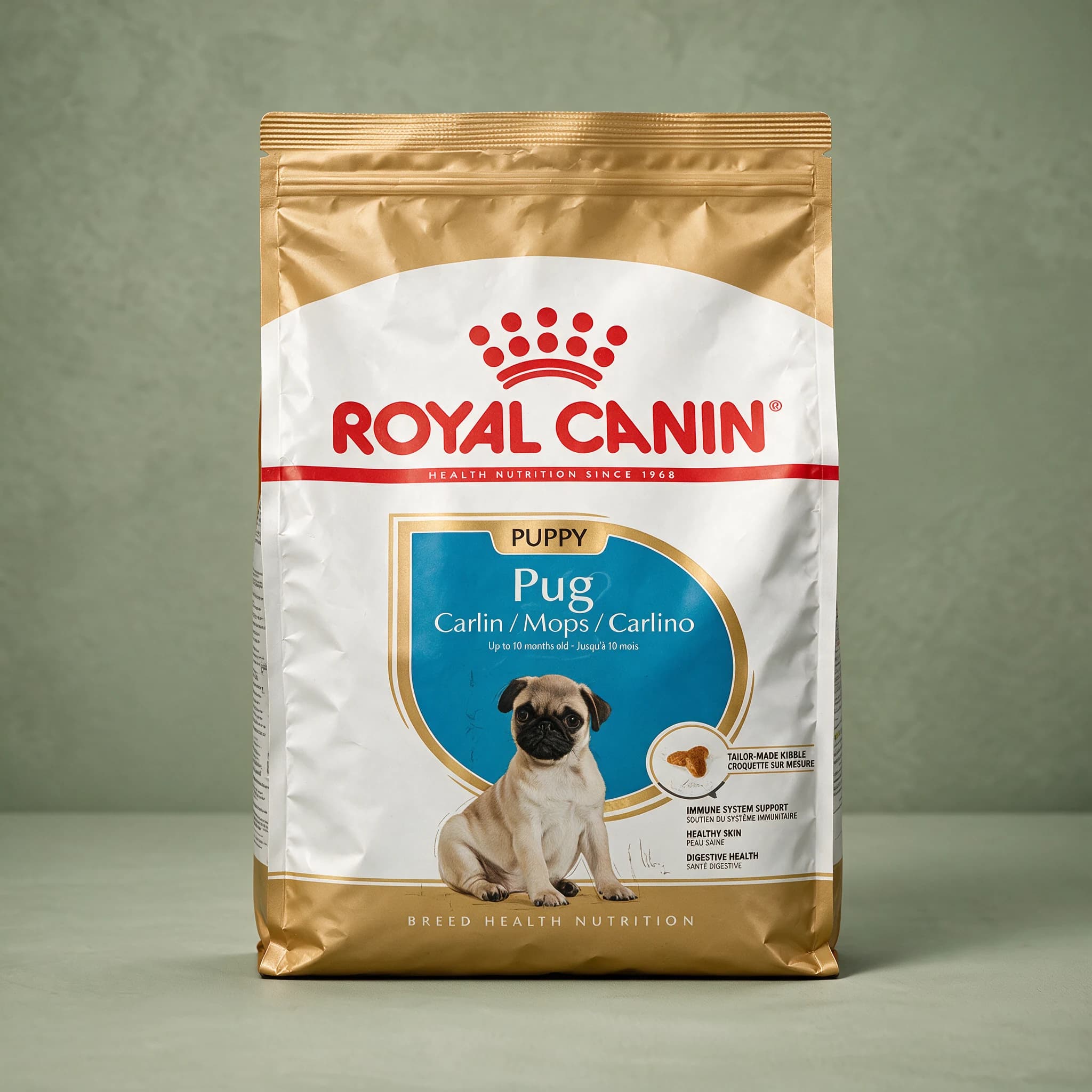 A gold and white Royal Canin Pug Puppy dry dog food bag with an illustrated Pug puppy on the front, photographed against a plain sage green studio background.